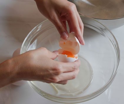 Partiendo huevo en bowl de cristal